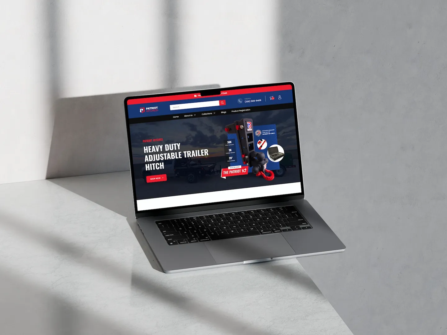 The Patriot Hitches storefront open on a laptop resting on a marble surface
